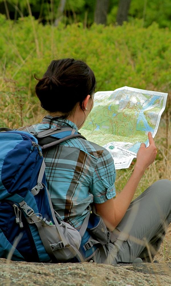 Pessoa consulta um mapa durante uma caminhada.